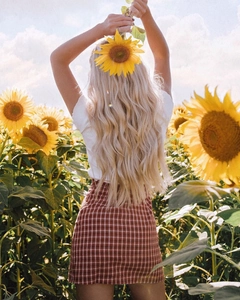 Vue arrière détaillée d'une mini-jupe à carreaux taille haute dans un champ de tournesols