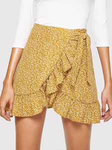 Detail of high waisted yellow floral wrap skirt with ruffle hem and waist tie