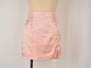 Détail de la mini-jupe en satin imprimé léopard rose avec fente latérale et fermeture éclair