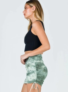 Close-up of ruched side drawstring detail on a green tie-dye high-waist mini skirt