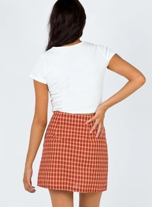 Vue arrière d'un mannequin portant une mini-jupe à carreaux rouges et un crop top blanc