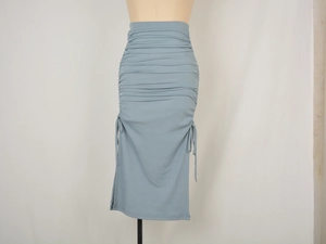 Detailed view of ruched drawstring side and ribbed knit texture on high waist skirt