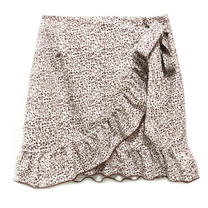Detail of floral wrap skirt showing delicate ruffle hem and adjustable waist tie