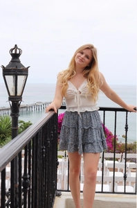 Close-up of a blue floral tiered ruffle mini skirt and white lace camisole for summer