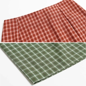Gros plan détaillé des textures de tissu à carreaux rouges et verts et des coutures
