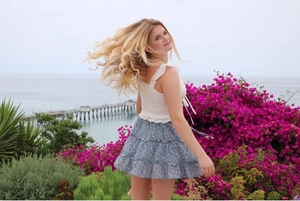 Detail of high waisted tiered floral skirt and lace ruffle top set for summer vacation
