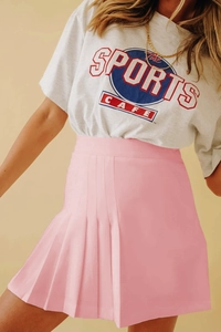 Détail de la texture plissée nette et de la taille haute de la jupe rose clair