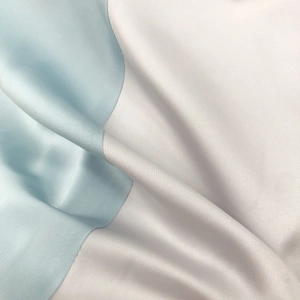 Detail-Makroaufnahme aus hellblauem und silbernem Satin mit elegantem Perlglanz-Effekt