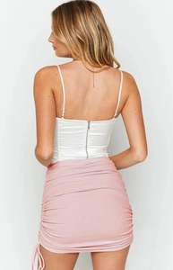 Detail of white satin camisole with metal zipper and pink ruched skirt with side drawstring