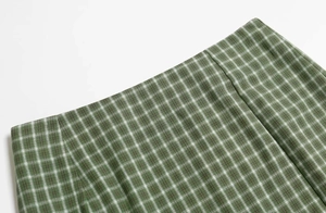 Détail du tissu à carreaux vert et blanc avec coutures soignées sur la jupe à taille haute