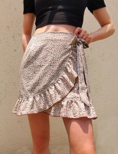 Detail of high waisted floral wrap mini skirt with ruffle hem and waist tie closure