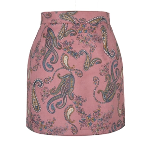 Détail du motif cachemire sur le tissu en daim rose de la jupe courte évasée