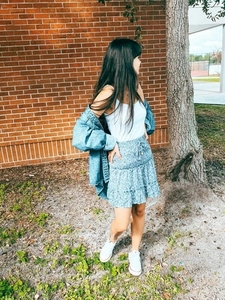 Detail of high waisted floral mini skirt featuring tiered ruffles and drawstring waist
