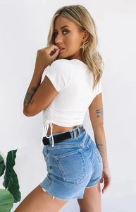 Close-up of white ribbed crop top with stylish drawstring side details and texture