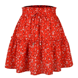 Détail d'une jupe courte rouge à fleurs avec taille élastique à volants et cordon de serrage