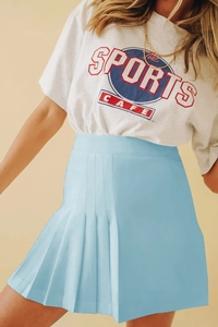 Détail d'une jupe de tennis plissée bleu clair avec un t-shirt blanc de style rétro