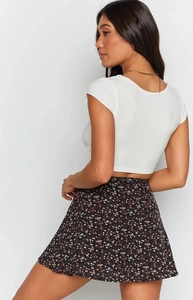 Detail view of floral mini skirt back with invisible zipper and fitted white crop top