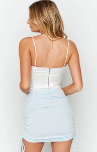 Close-up of side drawstring and ruched texture on a blue bodycon mini skirt