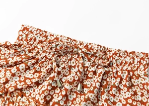 Close-up of floral high waist skirt with elastic smocked waist and drawstring detail