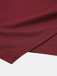 Gros plan sur le tissu tricoté bordeaux montrant la double couture fine de l'ourlet