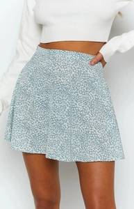 Detail of high waist light blue floral mini skirt with white flower print and A-line cut