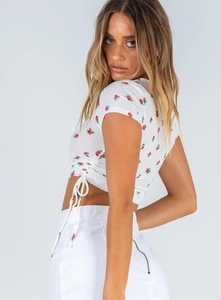 Detail of white crop top featuring red rose print and side adjustable drawstring ruching