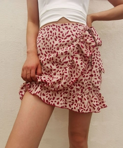 Detail of high waisted leopard print mini skirt with ruffle trim and side tie closure