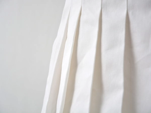 Détails de la texture du tissu blanc du jupe plissée avec des plis uniformes et nets