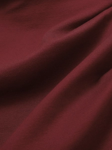 Vue macro d'un tissu tricoté rouge foncé montrant la texture douce et les plis