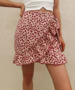 Detail of red leopard print mini skirt featuring side bow tie and ruffled hemline