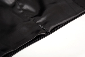 Détail de la fermeture éclair invisible sur une jupe en satin noir de qualité