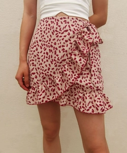 Detail of pink leopard print wrap skirt with ruffle hem and side tie-knot bow