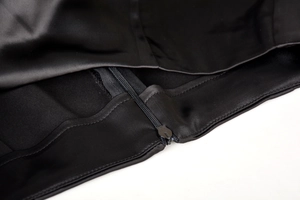 Détail de la fermeture éclair invisible sur jupe en satin noir avec coutures précises