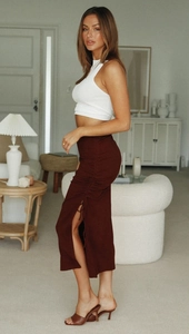 Detail of the high-waisted side drawstring ruching and split on the knit midi skirt