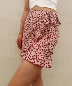 Detailed view of leopard print wrap skirt with waist tie bow and ruffled hemline