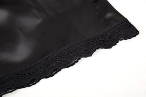 Détail de l'ourlet de la jupe en satin noir avec bordure en dentelle florale fine