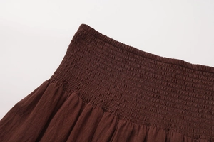 Detail of high waisted smocked elastic waistband on dark brown A-line maxi skirt