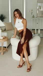 Detail view of high waist brown ruched midi skirt with a side slit and ribbed white top
