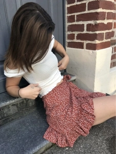 Detail of floral ruffle skirt with drawstring and white off-shoulder smocked crop top