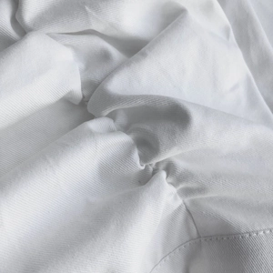 Close-up of white ruffled fabric texture with detailed stitching on high waist skirt