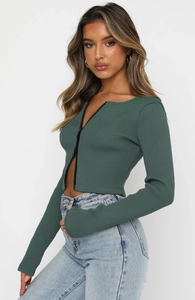 Detail of deep green ribbed long sleeve top featuring a sleek front zipper closure