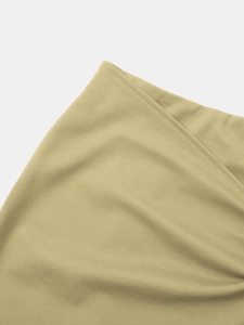 Gros plan des coutures fines et du tissu lisse sur le bord de la jupe beige asymétrique