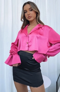 Détail d'une mini-jupe en satin noir à taille haute avec dentelle délicate au bord