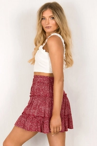 Detail of high waisted tiered floral mini skirt with ruffled edges and summer print
