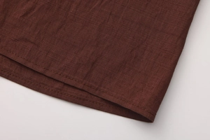 Detail shot of the hemline stitching on high waist brown cotton A-line skirt fabric