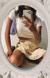 Mirror selfie showing floral chiffon skirt with ribbed crop top and purple handbag