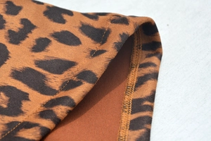 Gros plan du daim à motif léopard avec coutures à double aiguille et texture fine