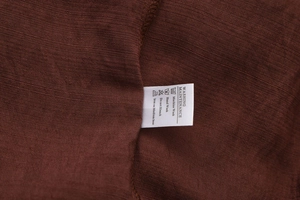 Macro shot of product washing maintenance label on dark brown A-line cotton maxi skirt