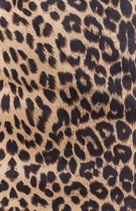 Gros plan sur la texture du tissu en suédine léopard avec motifs marron et noir
