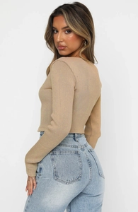 Detail of ribbed knit long sleeve top back tailoring and light wash denim jeans